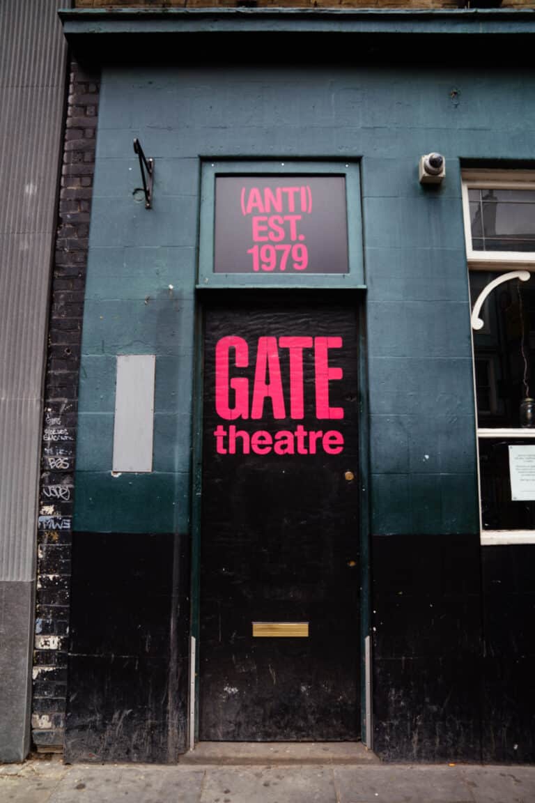 Exterior of former Gate Theatre home in Notting Hill showing a black door on the side of a pub with Gate Theatre branding
