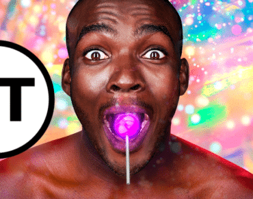Touch Tour symbol. Close up of a smiling, wide-eyed, bare-chested black man, with a glowing purple lollipop in his mouth. The background behind him is bright, multi-coloured and full of sparkles